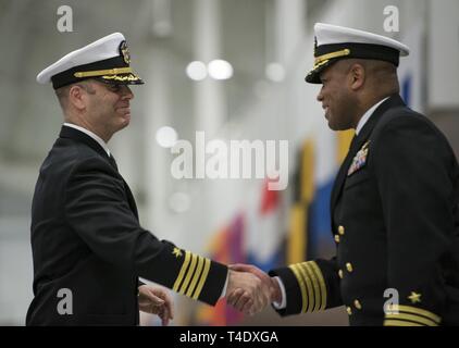 Grandi laghi, Ill. (22 marzo 2019) Capt. Kertreck Brooks, comandante della Naval istruzione e formazione per lo sviluppo professionale (centro destra), scuote le mani con il cap. Erik Thors, comandante del reclutamento di formazione comando, durante una passata in rassegna la cerimonia di laurea. Più di 35.000 reclute treno annualmente dalla marina è solo di boot camp. Foto Stock