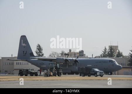 Un 374 Gruppo Operations zone di caduta personale di terra prepararsi a ricevere un basso costo di bassa altitudine airdrop fascio durante la Yokota C-130J Rodeo Marzo 22, 2019, a Yokota Air Base, Giappone. Il rodeo è una competizione amichevole fra i voli entro la trentaseiesima Airlift Squadron e il 374 operazioni squadrone di supporto che promuove la tattica di preparazione ed esecuzione delle varie funzionalità airlift. Foto Stock