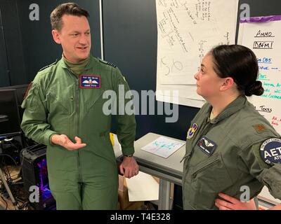 Stati Uniti Air Force Il Mag. Joanna Nelms, formazione pilota Avanti 2.0 medico di volo dal 359 Medical Group, parla di Royal Air Force Wing Commander Christopher pote, sede 22 del gruppo, all'PTN struttura presso le Forze Armate di riserva nel centro di Austin, Texas, Marzo 18, 2019. La RAF è la partecipazione in PTN della seconda iterazione in uno sforzo per accelerare l'apprendimento e aumentare la produzione pilota. Foto Stock