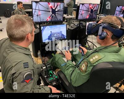 Royal Air Force Flight Lt. Darren francese (sinistra), formazione pilota Avanti 2.0 istruttore pilota e la RAF senior rappresentante nazionale, mutandine esercito britannico Col. Paddy Logan (centro), Assistente direttore per la formazione di volo per RAF sede 22 del gruppo, sulla tecnologia lezioni apprese presso il PTN struttura presso le Forze Armate di riserva nel centro di Austin, Texas, Marzo 18, 2019. La RAF è la partecipazione in PTN della seconda iterazione in uno sforzo per accelerare l'apprendimento e aumentare la produzione pilota. Foto Stock