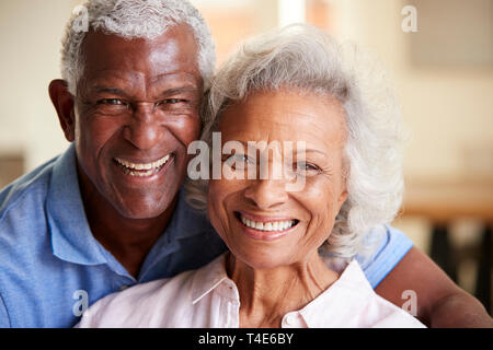 Ritratto di amorevole coppia Senior seduti sul divano di casa insieme Foto Stock