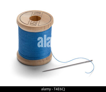 Filo blu sul rocchetto di legno con ago isolato su sfondo bianco. Foto Stock