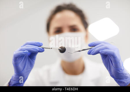 Chiusura del dentista femmina azienda strumenti mentre il trattamento paziente, spazio di copia Foto Stock