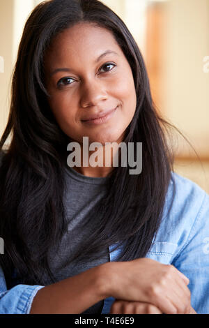 Ritratto Di Donna sorridente rilassante sul divano di casa Foto Stock