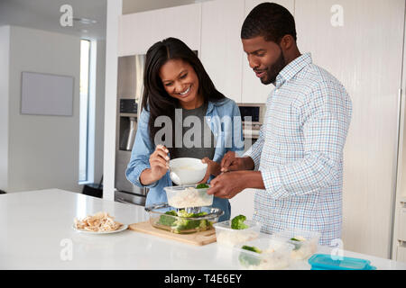 Matura in cucina la preparazione di alta farina proteica e la messa di porzioni in contenitori in plastica Foto Stock