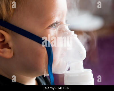 Ragazzo con gli occhi blu facendo chiudere inalazione fino Foto Stock