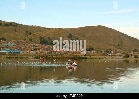 Le persone godono di racchetta in barca sul lago Titicaca in Puno città del Perù Foto Stock