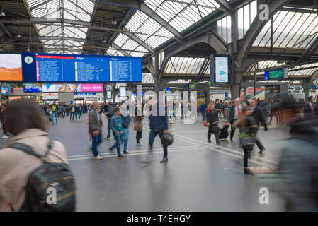 Zurigo, ZH / Svizzera - Aprile 8, 2019: Zurigo stazione ferroviaria e i treni partono con pendolari e persone fretta ai loro treni Foto Stock