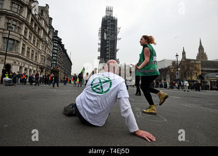 Un dimostrante durante una ribellione di estinzione protesta in piazza del Parlamento, Londra, come più di un centinaio di persone sono state arrestate polizia come trattare con il cambiamento climatico in corso proteste. Foto Stock