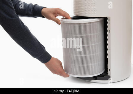 Una mano d'uomo girando un depuratore d'aria del filtro in uno nuovo. Foto Stock