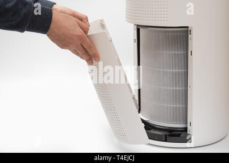 Una mano d'uomo girando un depuratore d'aria del filtro in uno nuovo. Foto Stock