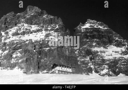 Lo chalet "Auronzo' sotto la montagna 'Drei Zinnen' nelle Dolomiti è il punto di partenza e punto di arrivo della montagna escursione fatto dagli alpinisti tedesco Peter Siegert, Rainer Kauschke e Gert Uhner (non datato foto di archivio da gennaio 1963). | Utilizzo di tutto il mondo Foto Stock