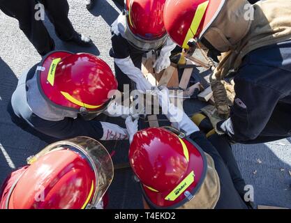 Stati Uniti I marinai della marina militare assegnato alla USS Gerald Ford (CVN 78) squadra volante pratica utilizzando un panno morbido patch durante un controllo del danno praticare in Newport News, Virginia, Marzo 27, 2019. Ford è attualmente in fase di post-shakedown disponibilità presso Huntington Ingalls Industries-Newport News la costruzione navale. Foto Stock