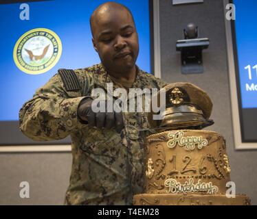 MILLINGTON, Tennessee (1 aprile 2019) specialista culinaria 2a classe Samuel caffè prepara una torta di compleanno per il chief petty officer's 126compleanno durante una funzione del comando a Navy assunzione di comando. Foto Stock