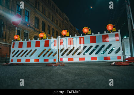 Le barriere stradali con lampade arancione come un recinto sulla riparazione su strada Foto Stock