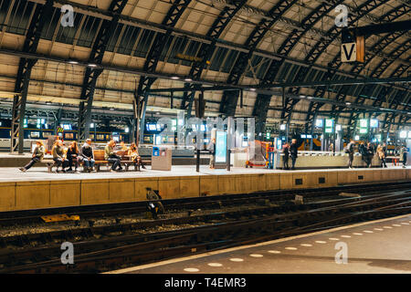 Dark grande stazione ferroviaria con interni moderni e piattaforme Foto Stock