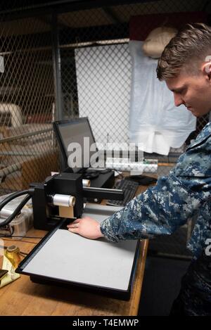 Hampton, Va. (marzo. 25, 2019) Aviation Ordnanceman Airman John Richardson, un marinaio da Abilene, Texas, e assegnata alla Nimitz-class portaerei USS George Washington (CVN 73)'s manutenzione preventiva divisione 14 (PM-14), opera un macchina per incisione alla luce impianto industriale (LIFAC). LIFAC è uno dei vari off-nave di impianti di produzione di George Washington si utilizza durante il rifornimento di carburante in fase di revisione complessa (RCOH) a Newport News Shipyard. RCOH è un quasi quattro anni di attività del progetto eseguita solo una volta durante un gestore del 50 anno di vita di servizio che comprende il rifornimento di carburante della nave t Foto Stock