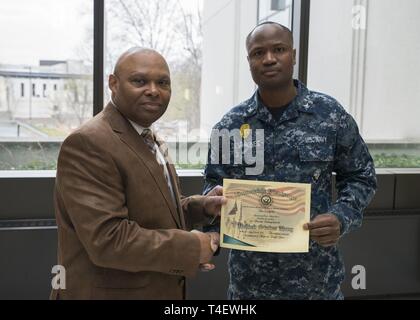 Master-at-Arms di terza classe Desravines Rodelin, un membro del supporto navale di Bethesda di attività delle forze di sicurezza, reenlisted nel Bldg. 17 atrium Aprile 5, 2019. Foto Stock