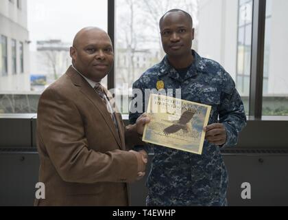 Master-at-Arms di terza classe Desravines Rodelin, un membro del supporto navale di Bethesda di attività delle forze di sicurezza, reenlisted nel Bldg. 17 atrium Aprile 5, 2019. Foto Stock