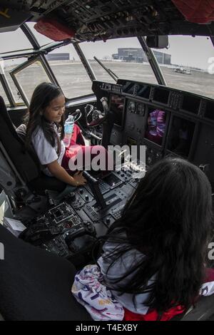 Gli studenti di bato Sapang Scuola elementare a sedersi in un pozzetto di un'U.S. Marine Corps KC-130J Super Hercules durante l'esercizio Balikatan a Clark Air Base, Filippine, 6 aprile 2019, durante l'esercizio Balikatan. Balikatan è un esercizio annuale tra gli Stati Uniti e le Filippine e proviene da una frase Tagalog significato houlder "a spalla", che rappresenta la relazione tra i due paesi. L'esercizio promuove la sicurezza regionale e gli sforzi umanitari per Stati Uniti alleati e partner. Foto Stock