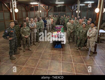 I partecipanti si riuniscono per una foto di gruppo a uno scambio culturale led evento dal Kenya Defence Force Lt. Col. Victor Mburu, una politica estera liaison officer assegnato a Combined Joint Task Force-Horn dell Africa (CJTF-HOA), a Camp Lemonnier, Gibuti, Marzo 27, 2019. CJTF-HOA detiene scambio mensile eventi con militare multinazionale di partner affiliati con Camp Lemonnier per rafforzare le alleanze e attrarre nuovi partner nel giunto combinato ambiente militare. Foto Stock