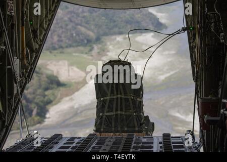 Rifornimento militare cargo scende al di fuori di un KC-130J Super Ercole da antenna Marine Refueler squadrone di trasporto 152 oltre il colonnello Ernesto Ravina Air Base, Filippine, 8 aprile 2019, durante l'esercizio Balikatan. Balikatan è un esercizio annuale tra gli Stati Uniti e le Filippine e proviene da una frase Tagalog significato houlder "a spalla", che rappresenta la relazione tra i due paesi. L'esercizio promuove la sicurezza regionale e gli sforzi umanitari per Stati Uniti alleati e partner. Foto Stock