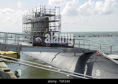 NORFOLK, Virginia (8 aprile 2019) - Il sig. Gregorio slavo, assistente segretario della Marina, pone con CDR. Sarà Willey, Comandante, USS John Warner (SSN 785), sul ciglio del John Warner, Aprile 8, 2019. In slavo è responsabile per la supervisione generale e la supervisione di manodopera e componenti di riserva gli affari del Dipartimento della Marina Militare, compreso lo sviluppo di programmi e politiche in materia di personale militare, i loro familiari e il personale civile. Foto Stock