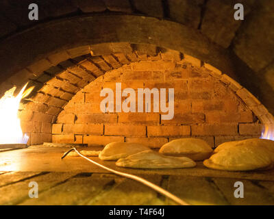 Pane Pita in tipico mattone legno pane pita è un tipo di pane piatto comune in Medio Oriente cucine. Foto Stock