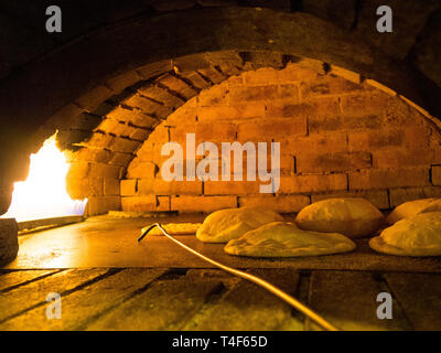 Pane Pita in tipico mattone legno pane pita è un tipo di pane piatto comune in Medio Oriente cucine. Foto Stock