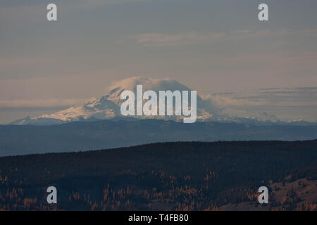 Mt Rainier visto dalla cresta di missione circa 69 miglia a nordest durante l'inverno appare molto grandi a causa della relativamente bassa terre che circondano il picco. Foto Stock