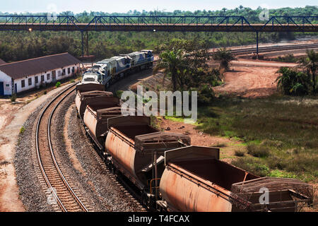 Rail & Port per le operazioni di gestione e il trasporto di minerale di ferro. Il treno sul binario ansa sotto il molo di carico nastro trasportatore dopo lo scarico, con i carri vuoti Foto Stock