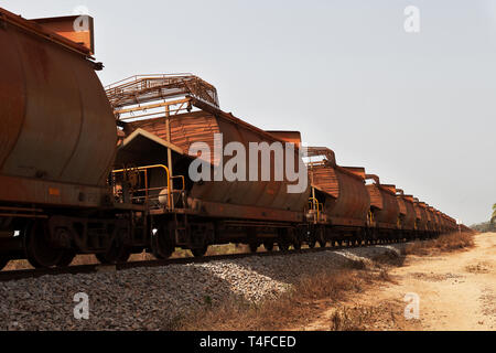 Operazioni portuali per la gestione e il trasporto di minerale di ferro. Per i carri ferroviari vicino area portuale che trasportano il minerale di ferro prima del carico su navi per i mercati esteri Foto Stock