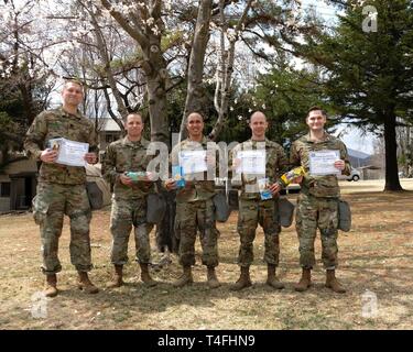 I comandanti con sede e Sede batteria, 210th campo brigata di artiglieria, seconda divisione di fanteria/ROK-STATI UNITI Divisione combinato, posano per una foto tenendo i cookie inviati loro da studenti della Università della North Carolina Executive Master of Business Administration di classe 2019, Aprile 11, 2019, il Camp Casey, Repubblica di Corea. Molti studenti inviati volontariamente Girl Scout cookie per uno degli ufficiali di condividere. Tre dei cinque ufficiali votato caramello piaceri come i loro preferiti cookie. Foto Stock