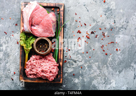 Crudo fresco carni bovine macinate sul tagliere e ingredienti Foto Stock