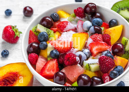 Ciotola di sana insalata di frutta fresca con yogurt. sano cibo vegan. dieta concetto. close up Foto Stock