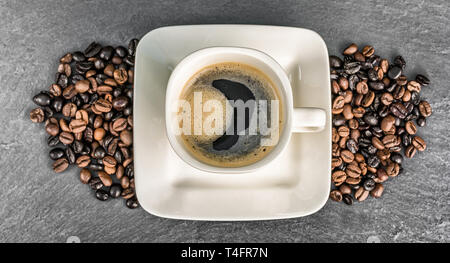 Panorama di una tazza di caffè con i chicchi di caffè su una piastra di ardesia Foto Stock