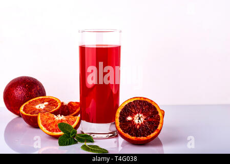 Bicchiere di succo di frutta con alcuni pezzi del siciliano di colore arancione su sfondo bianco. Siciliano di bevanda a base di arancia. Foto Stock