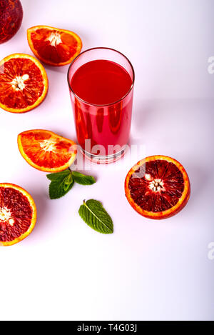 Bicchiere di succo di frutta con alcuni pezzi del siciliano di colore arancione su sfondo bianco. Siciliano di bevanda a base di arancia. Foto Stock