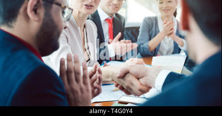 Team di uomini di affari che la negoziazione di un accordo la chiusura della trattativa Foto Stock