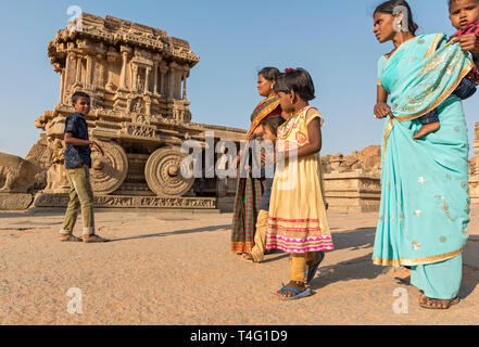 I visitatori nella parte anteriore del carro di pietra a Vijaya Vitthala tempio, Hampi, India Foto Stock