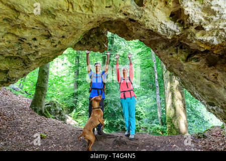 In alto le mani in una suggestiva grotta di roccia nella foresta Foto Stock