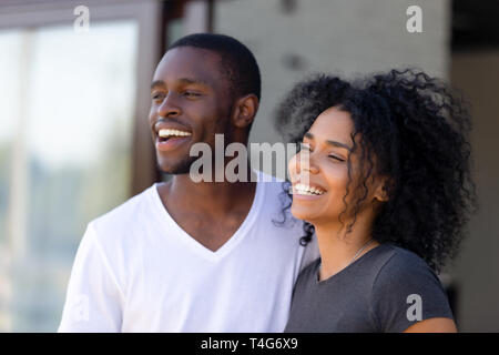 Sorridente americano africano giovane in piedi insieme all'aperto Foto Stock