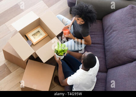 Vista superiore felice americano africano giovane in amore disimballare caselle a casa Foto Stock