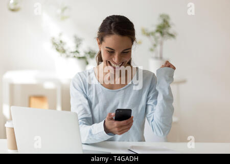 Donna felice guardando lo schermo del telefono sorridente Foto Stock