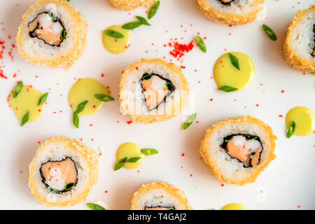 Rotoli di sushi sparsi su sfondo bianco close up Foto Stock