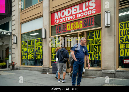 A Times Square posizione della family-owned sporting goods catena, Modell, viene intonacata con segni annunciando che il negozio è in fase di chiusura, visto a New York domenica 14 aprile, 2019. Pressione rivolta da online e big box retailer, Modell sportivo della merce è segnalato per aver ingaggiato un consigliere in materia di ristrutturazione e di un eventuale fallimento. (© Richard B. Levine) Foto Stock