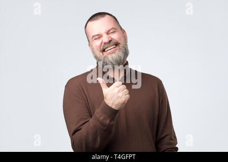 Coppia uomo caucasico dando pollice in alto e ridere isolato su sfondo grigio. Studio shot. Positivo l'emozione del viso. Foto Stock