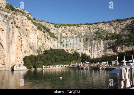 Il Lago di Vouliagmeni è una piccola salmastra acqua di lago alimentato da correnti sotterranee trafili attraverso la massa del monte Hymettus situato a sud della città di Atene Foto Stock