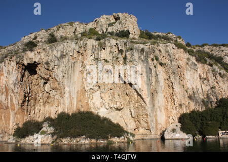 Il Lago di Vouliagmeni è una piccola salmastra acqua di lago alimentato da correnti sotterranee trafili attraverso la massa del monte Hymettus situato a sud della città di Atene Foto Stock