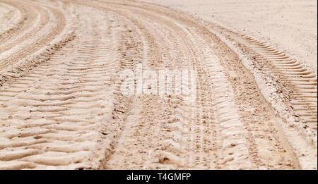 Tracce di pneumatici sulla sabbia costiera, trasporto texture di sfondo Foto Stock